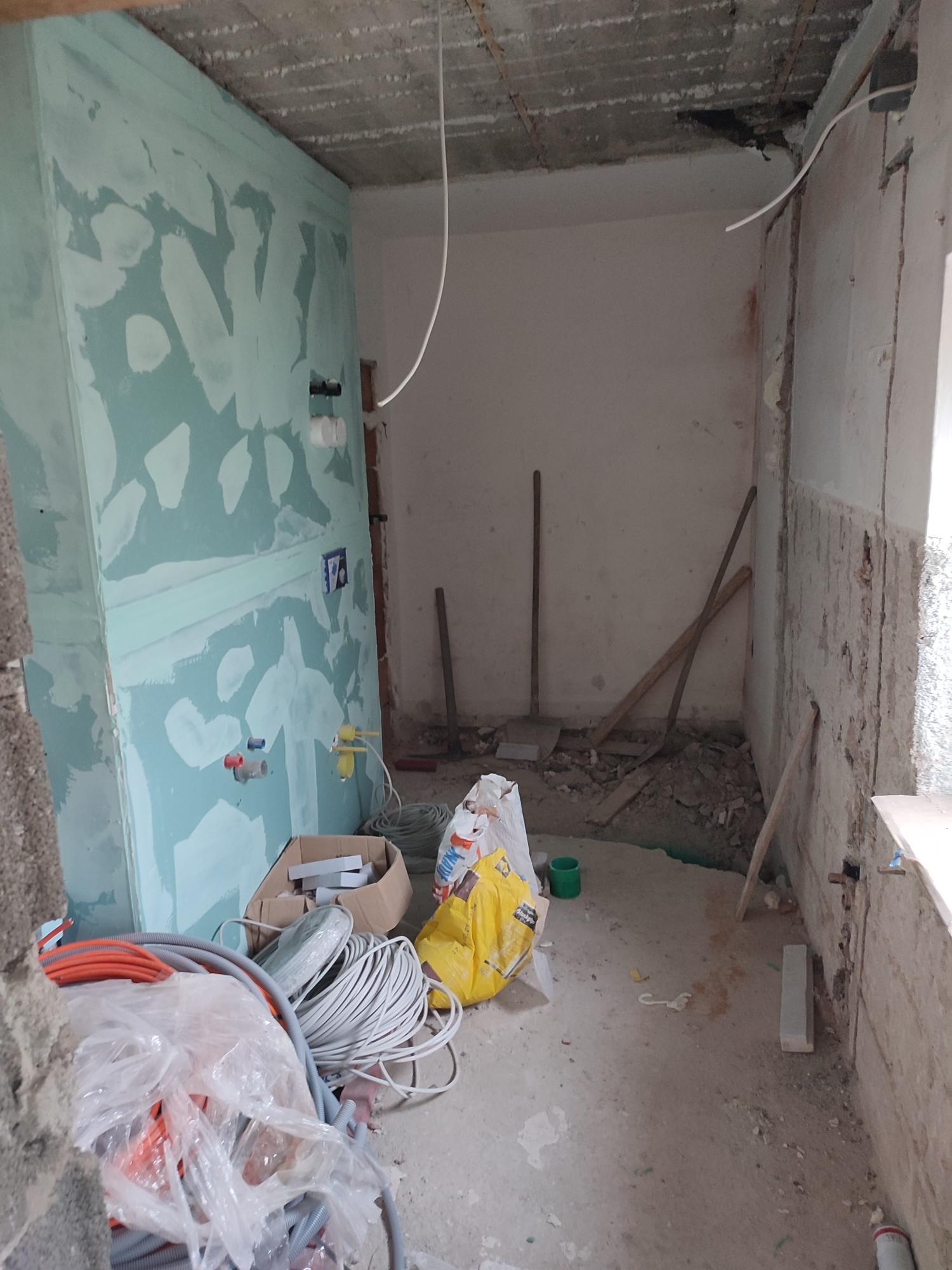 Bad im Rohbau: offene Decke, Vorwandinstallation, Baumaterial am Boden