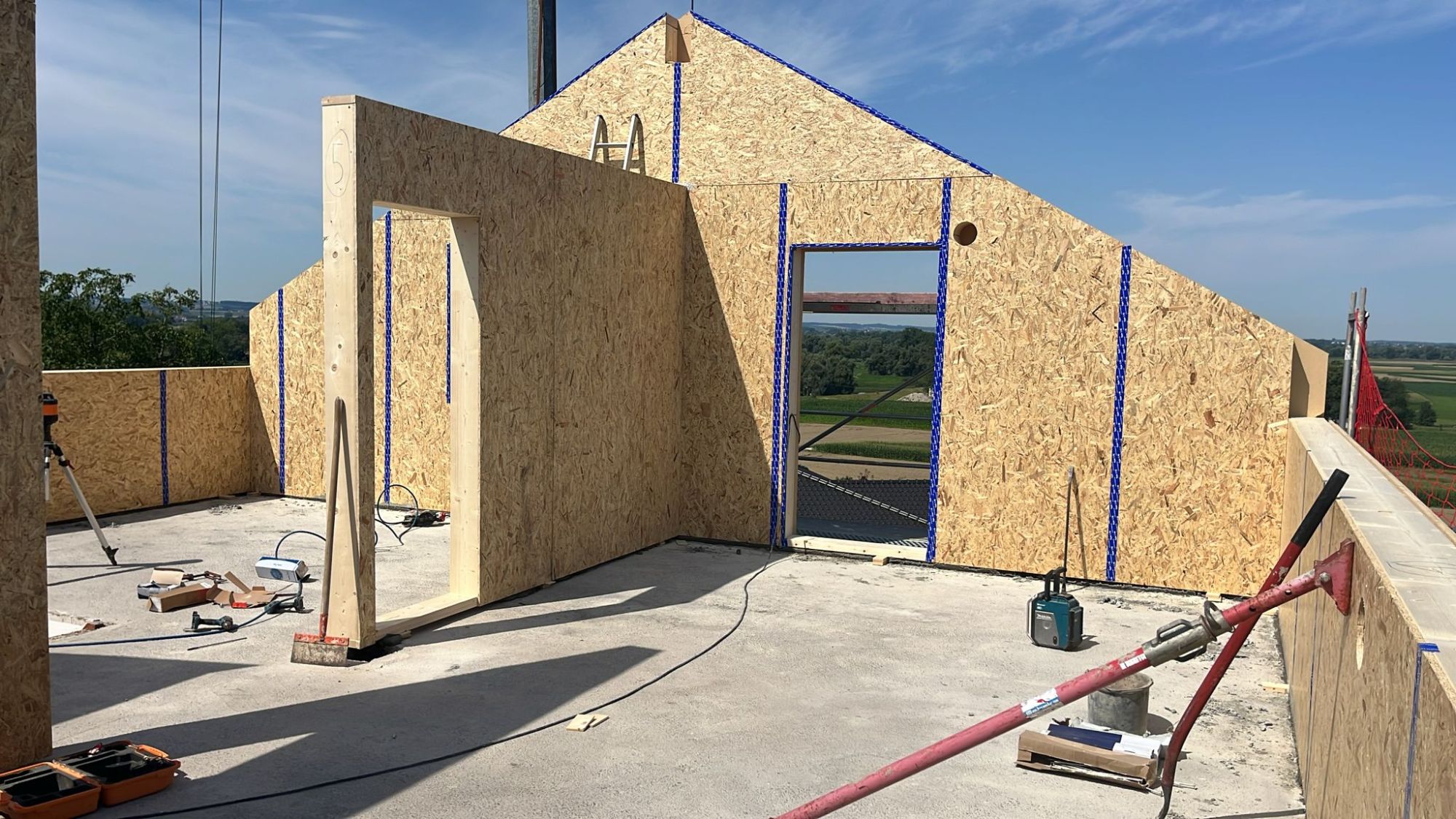 Dachgeschoss im Bau: Wände aus Holzplatten auf der Betondecke, Blick ins Freie